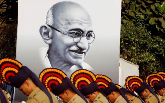 Police pay homage to Mohandas Gandhi near Mumbai, India, Jan. 30, 2008, the 60th anniversary of the assassination of the independence leader and peace icon. Mahatma Gandhi, as he was popularly known, was killed by a Hindu extremist in 1948. (CNS/Reuters/Punit Paranjpe)