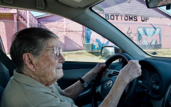 Sr. Julia Huiskamp drives past Bottoms Up, one of the four strip clubs in Brooklyn, Illinois. The strip clubs, a 24-hour massage parlor and a liquor store are the only businesses in the little town across the river from St. Louis. (GSR photo/Dan Stockman)