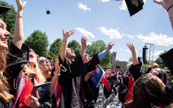 Graduates toss their caps in celebration at the Catholic University of America commencement ceremony May 17 in Washington.