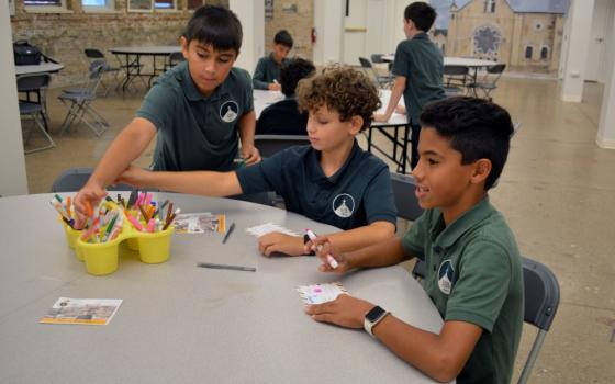 Fifth grade students at St. John Berchmans Elementary School, which is part of Blessed Carlo Acutis Parish in Chicago, fill out postcard invitations to the Sept. 7 Mass at their parish to commemorate the blessed's canonization in Rome, Sept. 3. (OSV News/Simone Orendain)