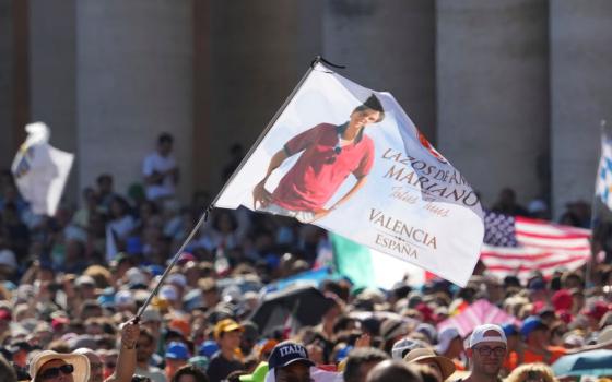 A flag featuring the image of Carlo Acutis is waved during the canonization Mass of Carlo Acutis and Pier Giorgio Frassati in St. Peter's Square at the Vatican on Sept. 7. (AP/Andrew Medichini)