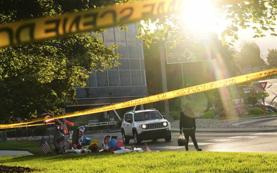 A person walks by a growing memorial at Utah Valley University after Turning Point USA CEO and co-founder Charlie Kirk was shot and killed Sept. 13, 2025, in Orem, Utah. (AP photo/Lindsey Wasson)