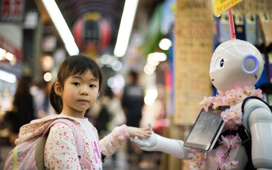 Girl holding the hand of a robot