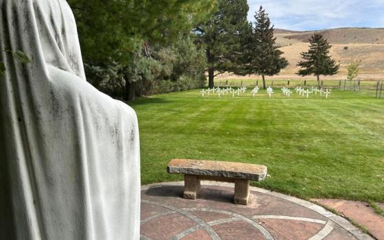 Statue of Mary overlooks cemetery.