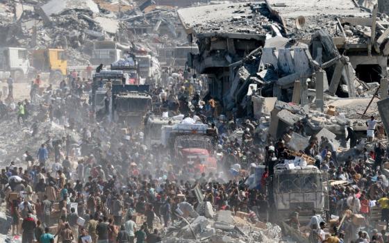 Palestinians collect aid supplies from trucks that entered the Gaza Strip, amid a ceasefire between Israel and Hamas in Gaza City, Oct. 12, 2025. (OSV News/Reuters/Ramadan Abed)