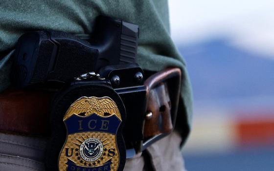 The badge and gun of a U.S. Immigration and Customs Enforcement agent is seen during an operation with migrants being transferred to a plane to be expelled under U.S. Title 42 from the United States to their home country by ICE and Border Patrol agents, at the airport in El Paso, Texas, May 10, 2023. (OSV News/Reuters/Jose Luis Gonzalez)