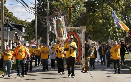 Immigrant activists make their way down Lexington St. on the way to the U.S. Immigration and Customs Enforcement facility in Broadview, Oct. 11 in Chicago. Hundreds followed the Eucharist from St. Eulalia Parish in Maywood to the Broadview facility operated by the Department of Homeland Security. The group hoped to give Communion to detainees at the center but were denied access. (Courtesy of Chicago Catholic/Karen Callaway)