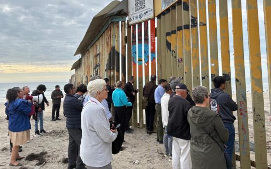 Attendees of the Colloquium on Migration and Theology reflect and pray at the border wall between Tijuana, Mexico, and San Diego, CA. (Luis Donaldo González)