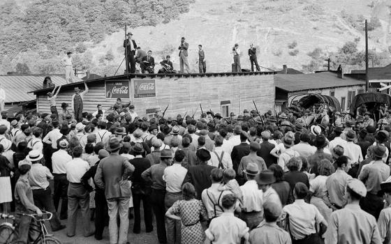 A local preacher on the roof of a building denounces the governor and a local judge for moving troops into Harlan County, Ky., in May 1939 during a coal miners strike. (AP)