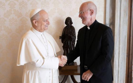Pope Leo XIV welcomes Jesuit Fr. James Martin, an author and editor at large at America magazine, to the library of the Apostolic Palace at the Vatican.
