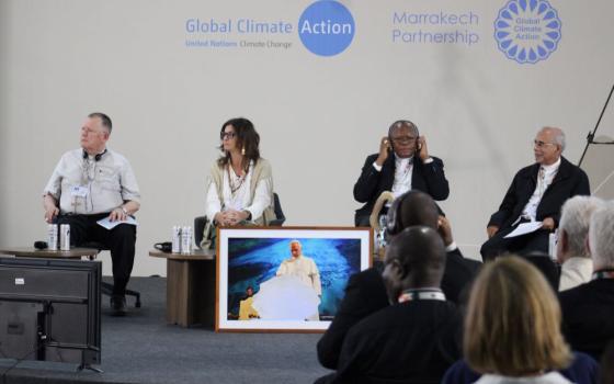 Presenters listen during an event Nov. 13 where Catholic leaders from the Global South discuss a letter demanding climate justice at COP30 in Belém, Brazil. The picture shows Pope Leo blessing a block of ice from a glacier in Greenland during the opening session of an international conference.