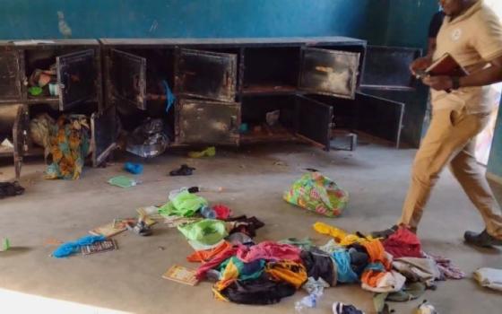 In this photo released by the Christian Association of Nigeria, a man walks past belongings at the St. Mary's Catholic Primary and Secondary School after gunmen abducted children and staff in Papiri community, Nigeria, Nov. 21. (AP/Christian Association of Nigeria)
