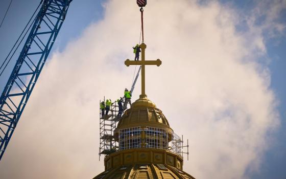 Construction workers install the main cross of the People's Salvation Cathedral, known as the National Cathedral, in Bucharest, Romania, April 8, 2025. The Christian Orthodox church opened Nov. 2 after 15 years of construction. (AP/Vadim Ghirda, File)