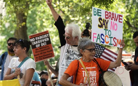 Activists carry signs during a protest against President Donald Trump's federal takeover of policing of the District of Columbia, Saturday, Aug. 16, 2025, in Washington. (AP photo/Alex Brandon)