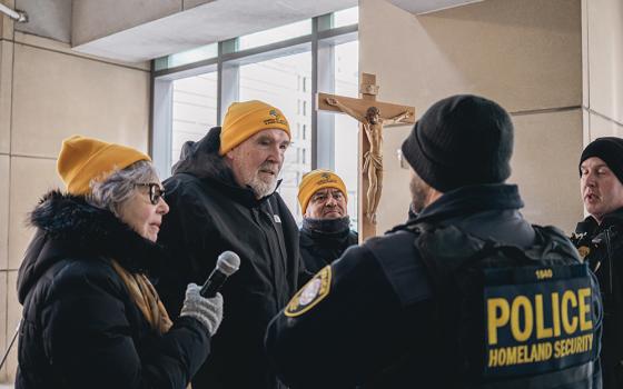 Fr. Dennis Berry, center, and Felician Sr. Jeremy Midura, left, talk to a Department of Homeland Security official outside the U.S. Immigration and Customs Enforcement's Chicago field office, Dec. 19. (Courtesy of Coalition for Spiritual and Public Leadership/Bryan Sebastian)