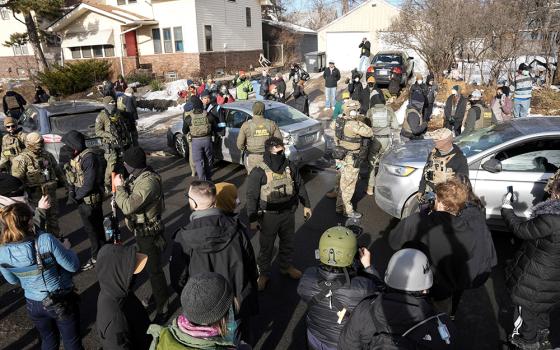 Federal agents stand by a damaged civilian's car hit by U.S. Immigration and Customs Enforcement agents in Minneapolis Jan.12, 2026, during ongoing demonstrations against ICE. (OSV News/Reuters/Tim Evans)
