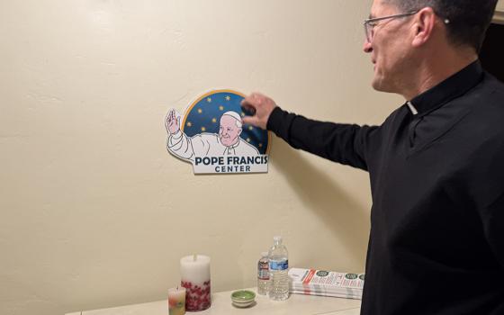 Jesuit Fr. Scott Santarosa, the pastor of Our Lady of Guadalupe Parish in San Diego, points out the Pope Francis Center's logo in the front entrance of the building. (Anna Weaver)