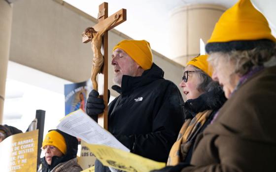 Fr. Dennis Berry, a member of the Missionary Servants of the Most Holy Trinity, holds a crucifix during a news conference outside the Immigration and Customs Enforcement office at the Federal Building in Chicago Dec. 19, 2025. (OSV News/Hailey Hoffman)