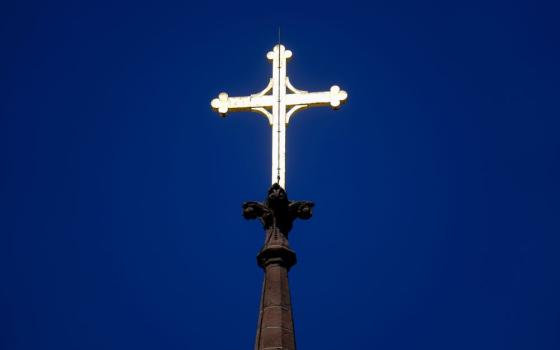 A cross is silhouetted against a stained glass window inside a Catholic Church in New Orleans on Dec. 1, 2012. (AP/Gerald Herbert, file)