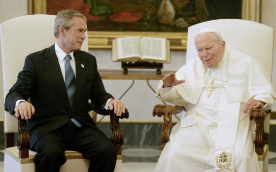 Pope John Paul II talks with U.S. President George W. Bush at the Vatican June 4, 2004, their first meeting after the Iraq war began. The pope, a vocal opponent of the war in Iraq, called for a speedy return to Iraqi sovereignty. (CNS/Reuters)