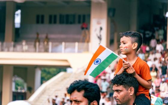 A child on a man's shoulders holds an Indian flag in Attari, Punjab, India, Feb. 13, 2025. (Unsplash/Raju Kumar)