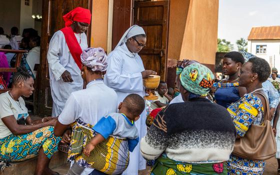 A nun distributes Communion during Mass outside the Cathedral of Our Lady of Graces in Ituri, Congo, May 24, 2026, amid a resurgence of Ebola involving the Bundibugyo strain, a rarer variant of the virus with no approved vaccine currently available. (OSV News/Reuters)