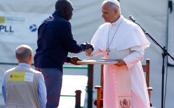 Pope Leo XIV receives a photo collage from Senegalese migrant Theodor Faye at the "Las Raices" migrant center in Tenerife, Canary Islands, Spain, June 12, 2026. (OSV News/Borja Suarez)