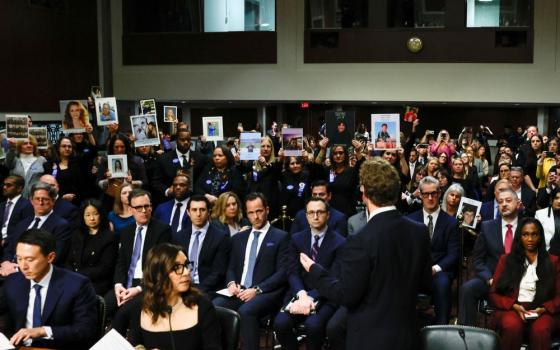 Meta's CEO Mark Zuckerberg stands and faces the audience holding up photos of their children as he testifies during the Senate Judiciary Committee hearing on online child sexual exploitation at the U.S. Capitol in Washington Jan. 31, 2024. (OSV News/Reuters/Evelyn Hockstein)