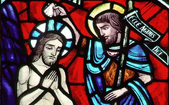 A church window depicts Christ's baptism by John the Baptist at the Jordan River. (CNS/Crosiers) 