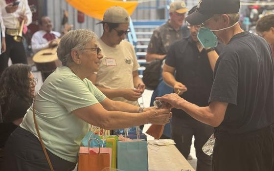 Rochester Franciscan Sr. Phyllis Sellner, of Palm Desert, California, hands goody bags to men at the Cobina Posada del Migrante shelter where sisters and their friends celebrated Father’s Day June 6, 2026, in Mexicali, Mexico. (GSR photo/Rhina Guidos)