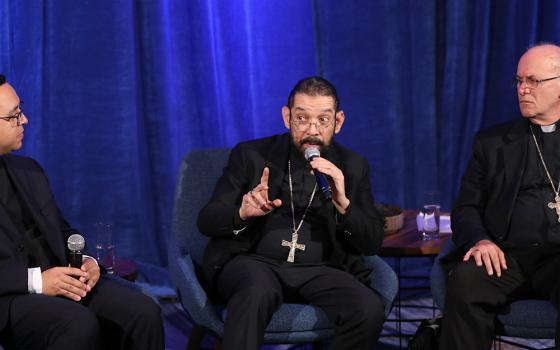 Bishop Daniel E. Flores of Brownsville, Texas, speaks at a news conference during a Nov. 14, 2023, session of the fall general assembly of the U.S. bishops in Baltimore. Also pictured are Fr. Iván Montelongo, of the Diocese of El Paso, Texas, and Bishop Kevin C. Rhoades of Fort Wayne-South Bend, Indiana. (OSV News photo/Bob Roller)