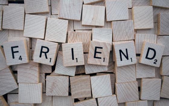 Scrabble tiles spell "friend."