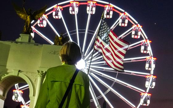 A person carries an American flag at the Great American State Fair, Tuesday, June 30, 2026, on the National Mall in Washington. (AP/Julia Demaree Nikhinson)