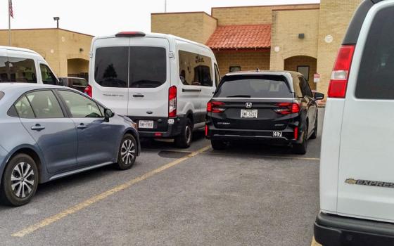 White vans parked outside the immigration courts in Harlingen, Texas, means there are unaccompanied minors with immigration hearings that day. The children travel in the vans from shelters where they stay until they can be placed with relatives or a guardian, or be deported. (Courtesy of Rose Kuhn)