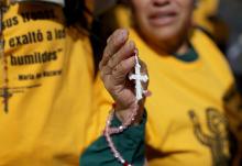 A woman holds a rosary as members of a Catholic group take part in a Eucharistic procession near the U.S. Immigration and Customs Enforcement (ICE) Broadview facility in Chicago Oct. 11, 2025. The group had hoped to share holy Communion with detainees at the facility. (OSV News/Reuters/Jeenah Moon)
