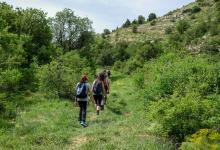 A group of people hiking a trail up a hill (Unsplash/Art of Hoping)